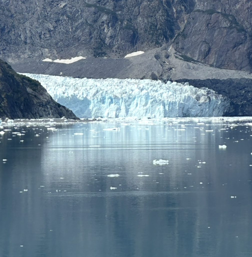 Johns Hopkins Glacier in Glacier Bay National Park, Alaska reflected in calm icy waters